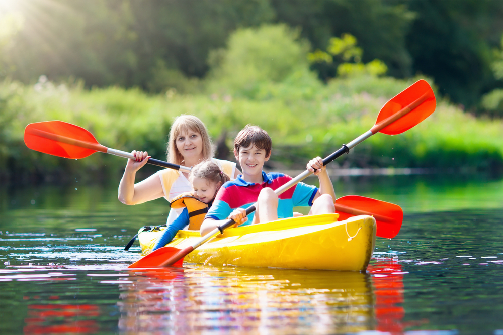 Kayaking in the oasis near Orlando with kids makes for fun adventures-- as shown with this mom as she navigates with her children in a yellow kayak.