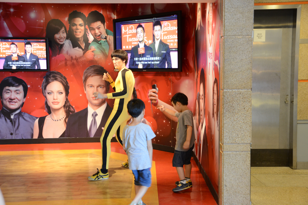 Two children approach a wax figure at Madam Tussauds. This interactive experience and museum makes photo taking fun, and is one of the things to do in Orlando with kids. 