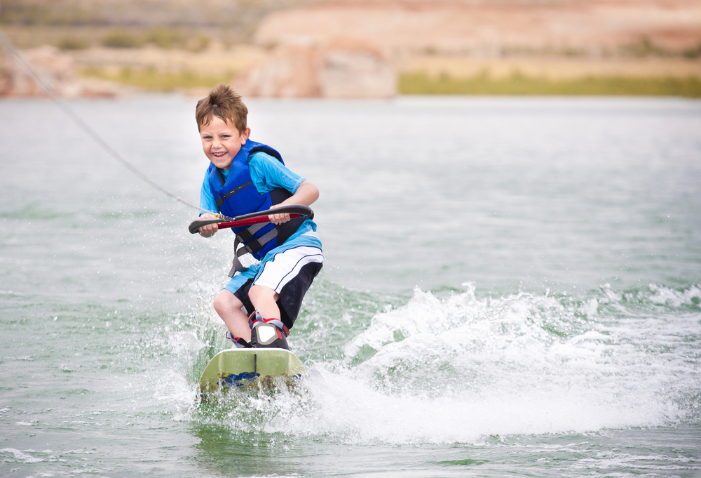 A young boy wakeboarding in the water