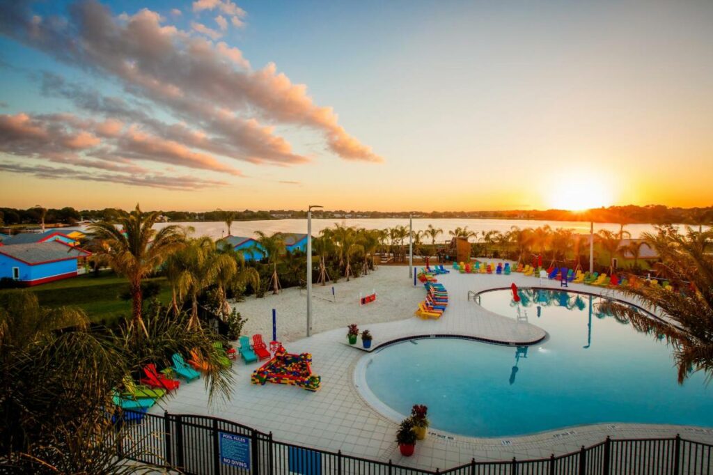 Sunset over a pool with colorful lounge chairs at Legoland Florida Resort.