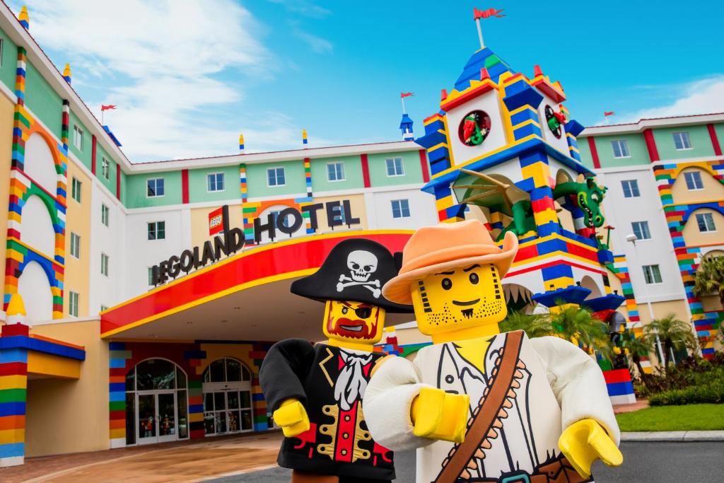outside the legoland hotel with two lego figures and the colorful hotel facade. 