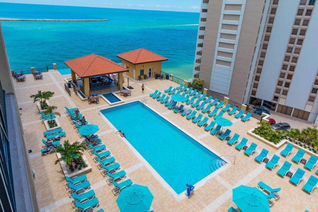 Looking down at a large pool with a hot tub, a bar, and a large area of loungers that is where to stay in Tampa Florida