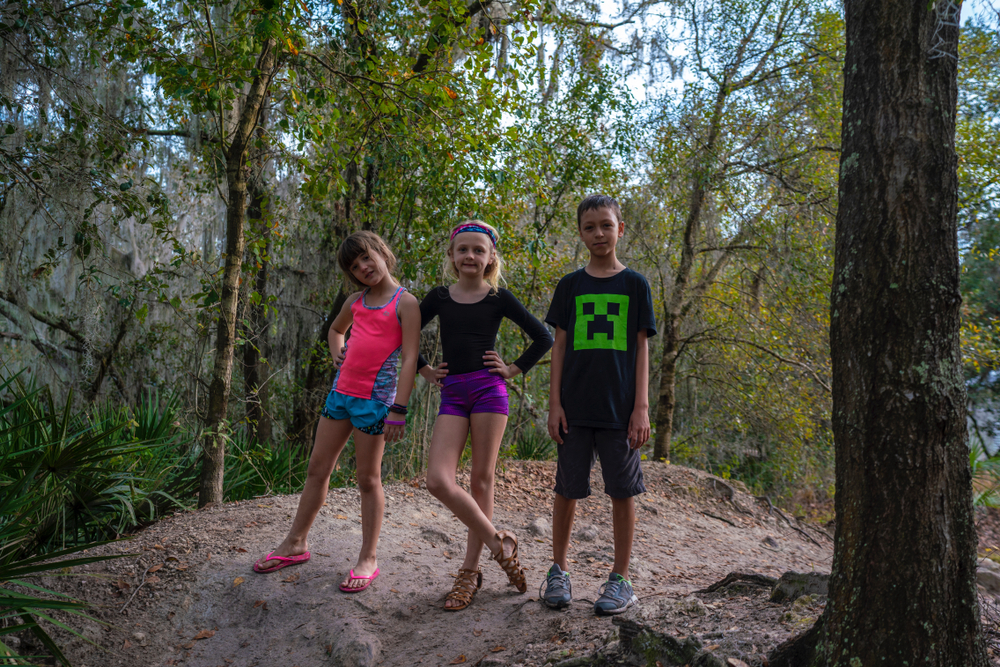 Kids in the forest being silly, playing and having lots of fun and laughter