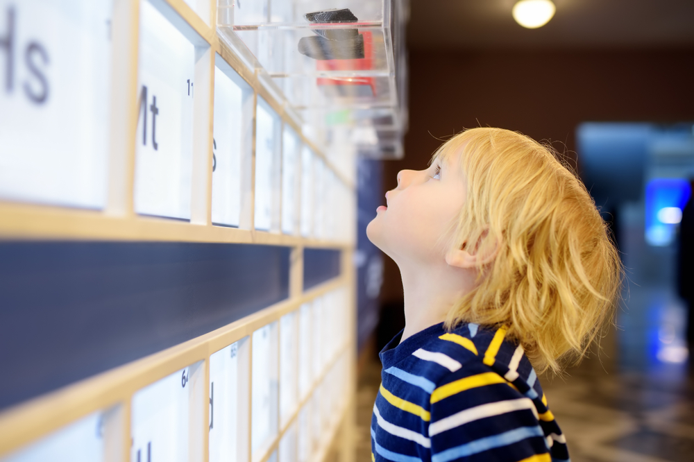 Child looking up at a scinece table 