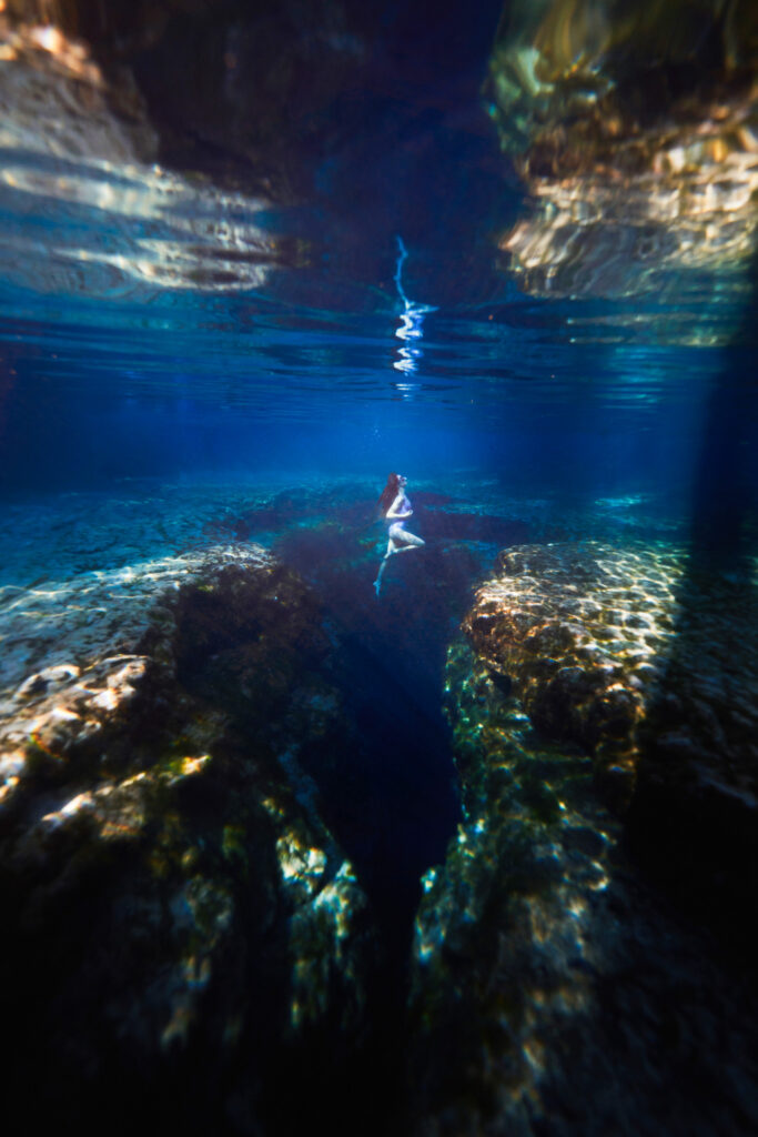 Underwater photo of a woman swimming in the clear water of Ginnie Springs.