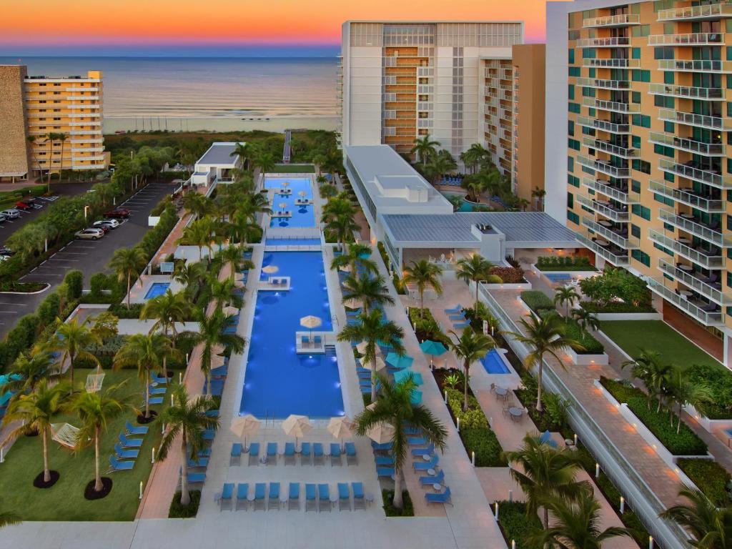 Multiple outdoor pools beside buildings overlooking the beach best beach resorts on Marco Island 