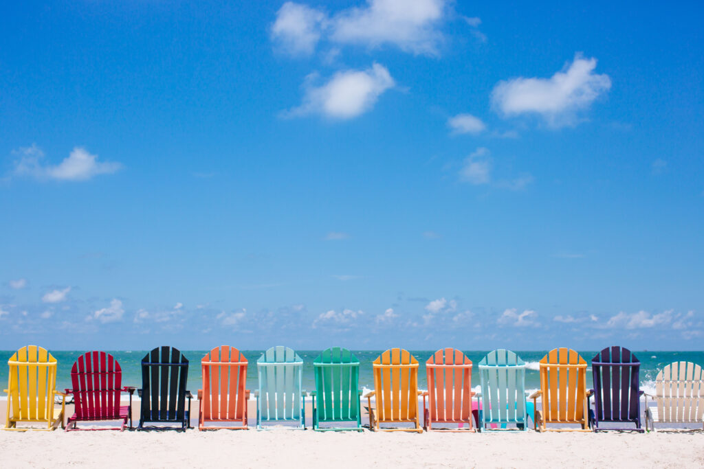 Colorful chairs by the shoreline on a bright sunny day