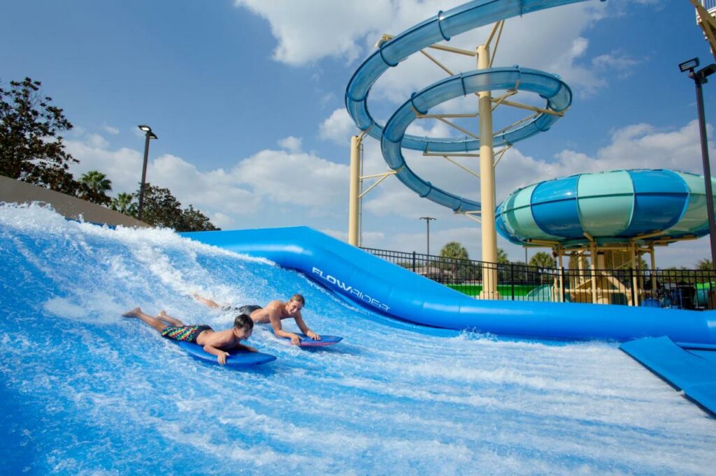 Two kids boogie board on a makeshift wave runner at Gaylord Palms which is one of  best waterpark hotels in Orlando.