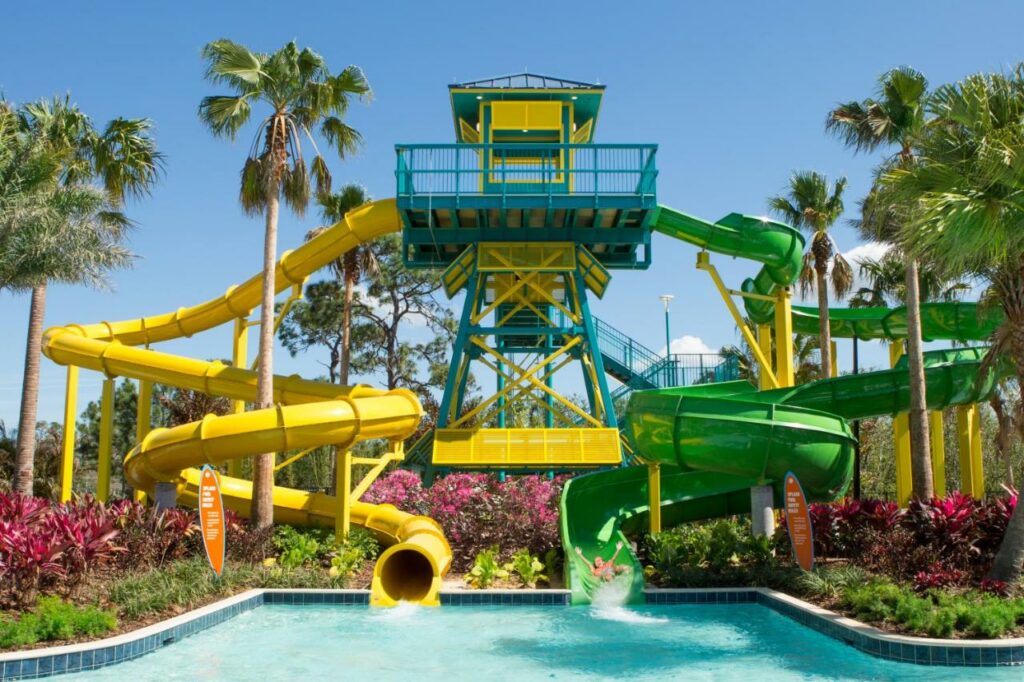 Two water slides, one green and one yellow, twist around at the Grove Resort hotel, one of the best waterpark hotels in Orlando. 