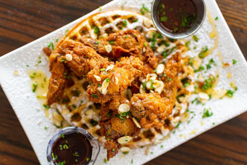 Fried chicken is heaped onto a waffle, with cups of maple syrup, like that served at Maxine's On Shine, one of the best restaurants in Orlando for brunch.