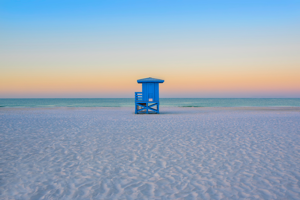 Siesta Key beach with a lifeguard stand at sunset empty white sand beach