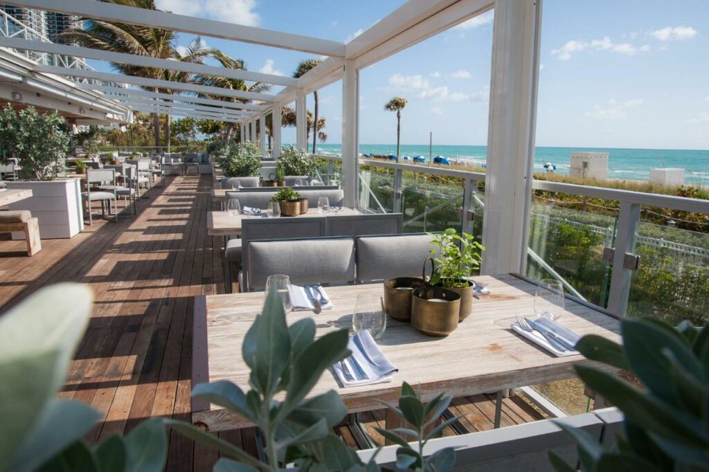 A picture of the outdoor restaurant at Eden Roc Miami Beach with the ocean in the background 