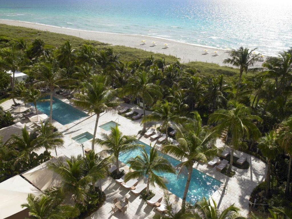 A picture of the pool area at grand beach hotel miami beach with the ocean in the background