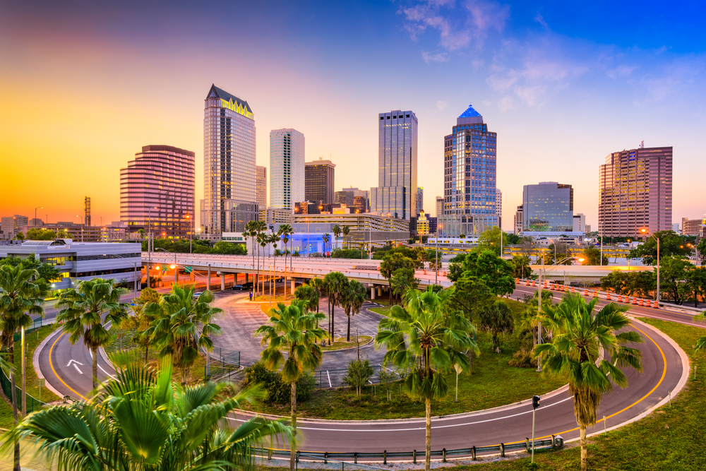 Photo of downtown Tampa, Florida with buildings, palm trees, and a sunset.