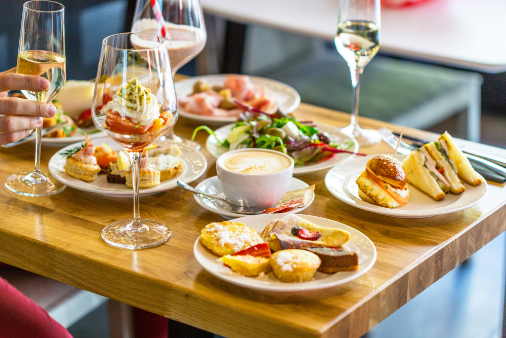 Small bites of sandwiches and salads with glasses on champagne at one of the best brunches in Tampa.  