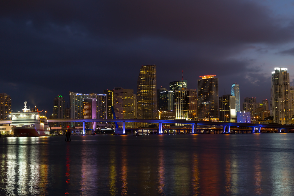The Miami skyline at night, where a cruise ship passes through Biscayne Bay, one of the best things to do in Miami for adults.