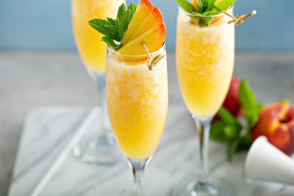 Three flutes of mimosas with peaches.