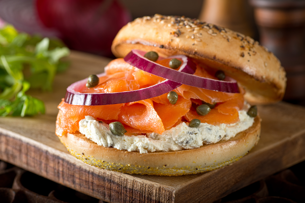 Bagel sandwich with salmon, cream cheese, capers, and onion.