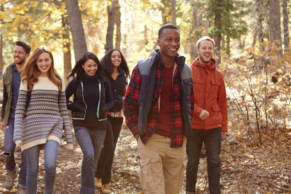 A group of six friends navigate the trees and leaves in the trails of Central Florida, all in autumn gear. This is one of the fun things to do in Orlando for adults.