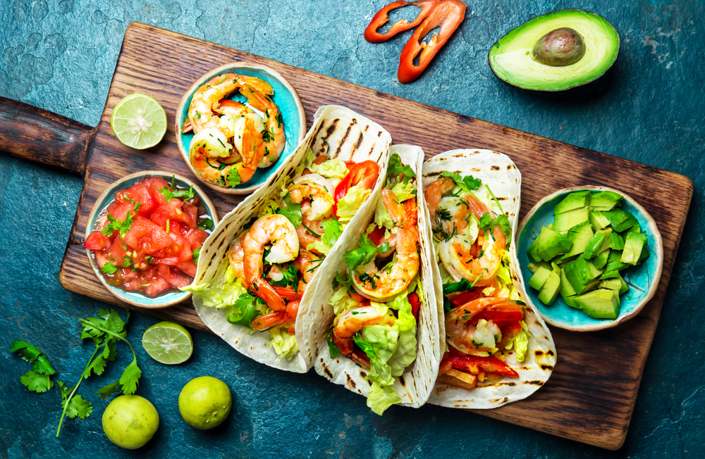 Shrimps tacos with salsa, vegetables and avocado. Mexican food.