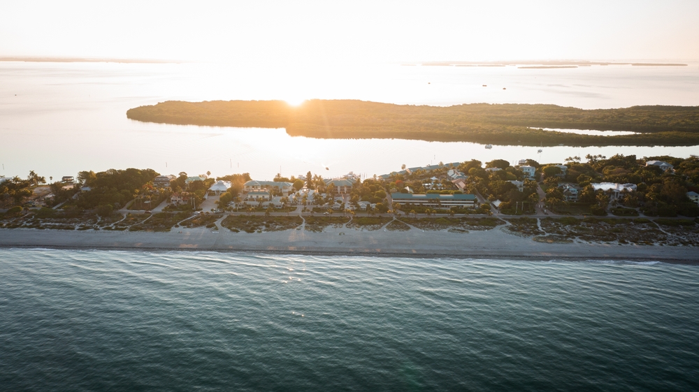 Sunrise over Buck Key, near Captiva Island, where houses are lined along the shore.