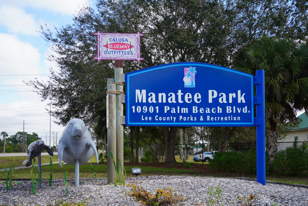 The sign for Manatee Park, with manatee sculptures next to it, which is one of the best places to see manatees while kayaking in Fort Myers.