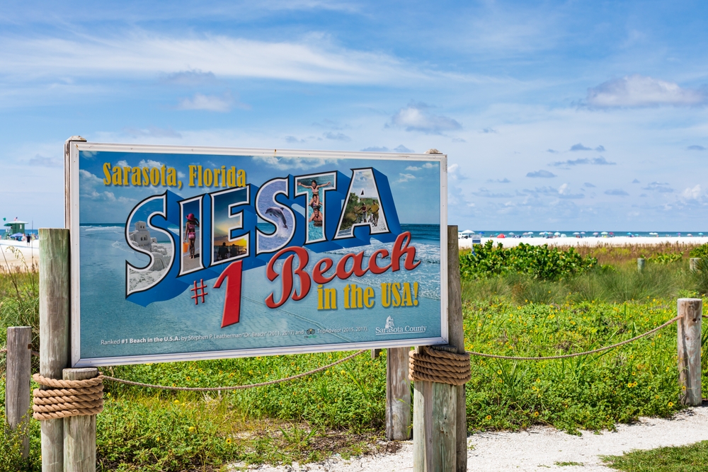 The Siesta Beach sign in Sarasota, FL helps direct tourist and locals to the best beach area, which includes some good food in the area too! 