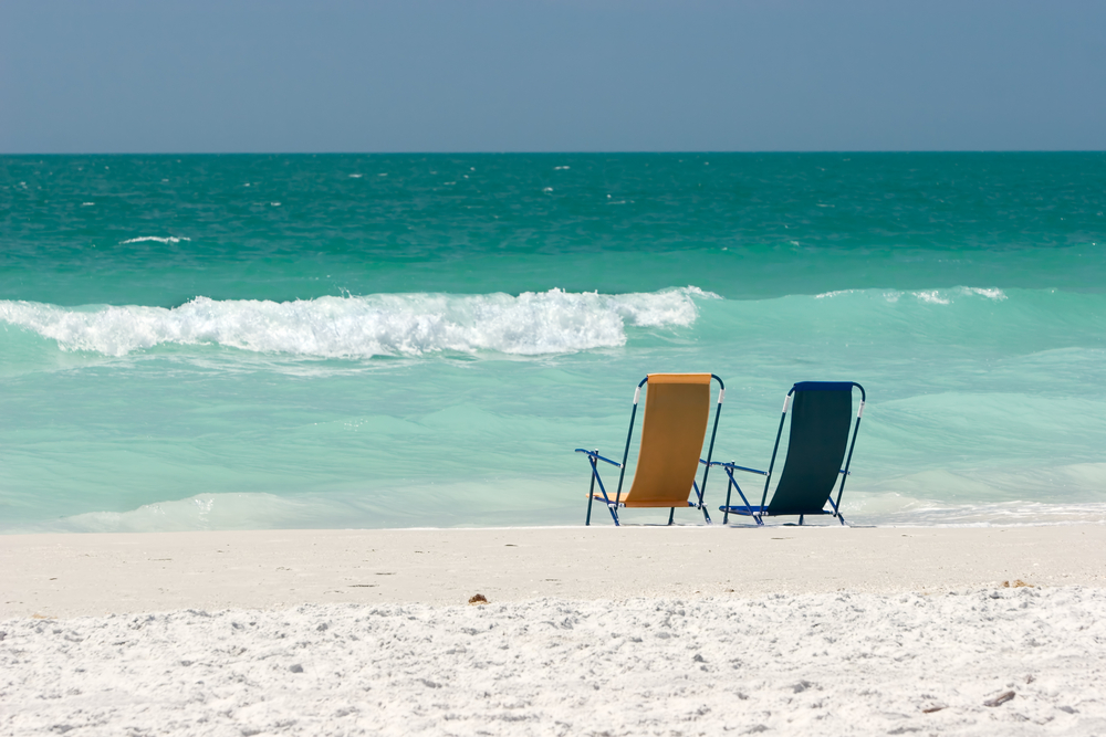 Two chairs in a beach. There is no one on the beach. The article is about secluded beaches in Florida
