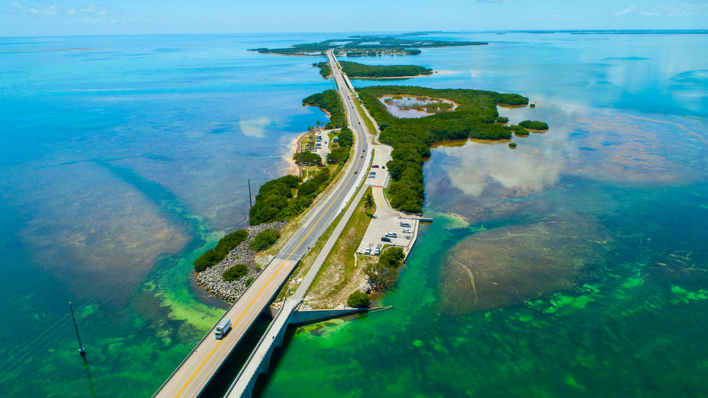 Aerial view of the road leading through the Florida Keys with islands surrounded by bright, clear water.