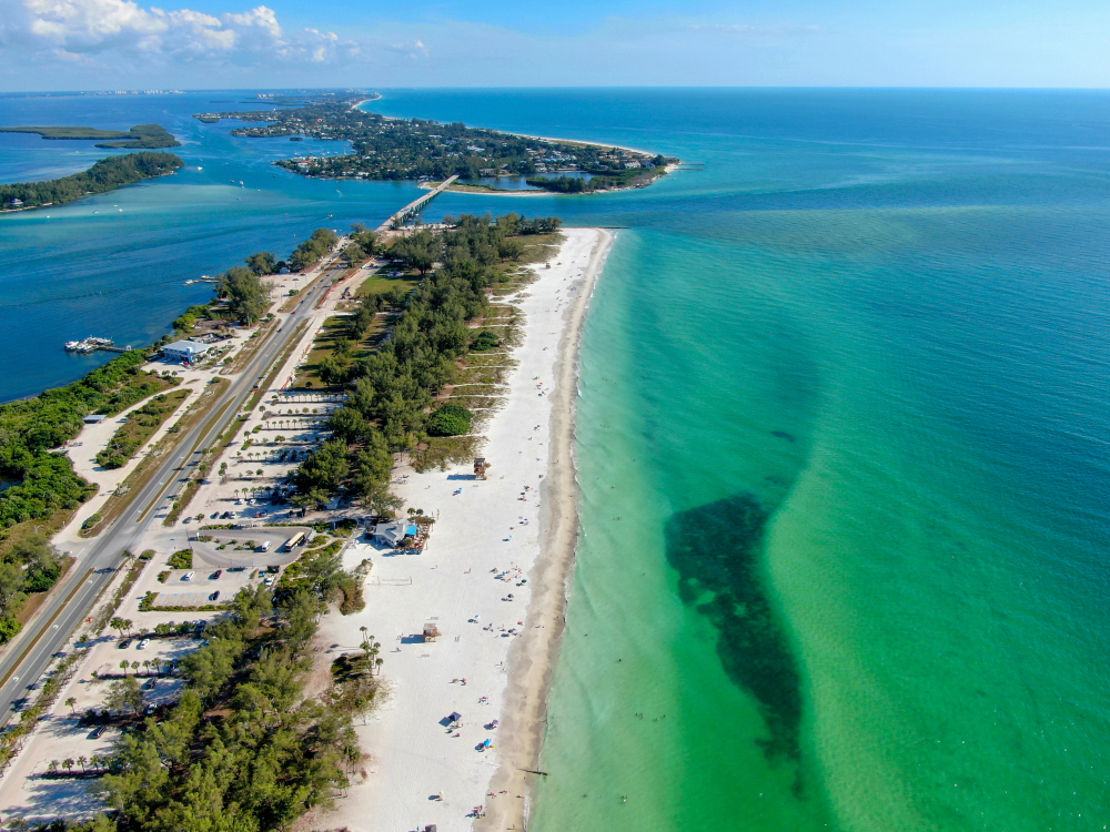 aerial view of a beach with white sandy and green-blue water beaches in anna maria island