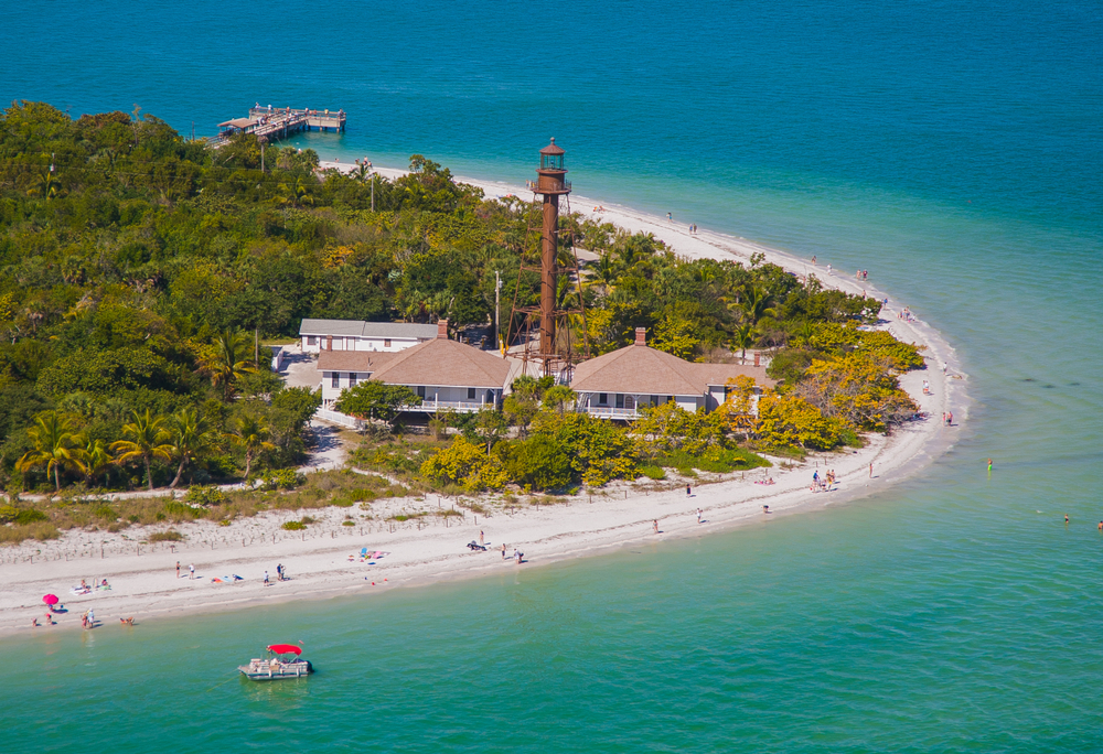 a beautiful island called Sanibel with a lighthouse pier and people enjoying one of the best florida gulf coast islands