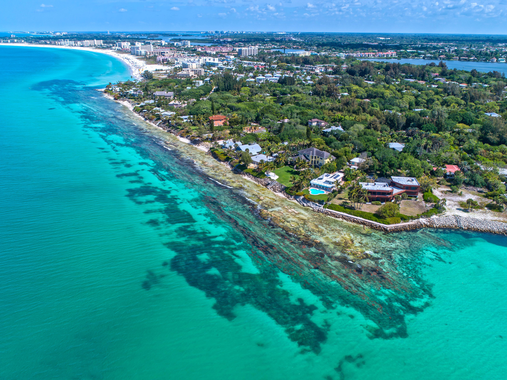 siesta key island on the gulf coast of florida with blue water and buildings