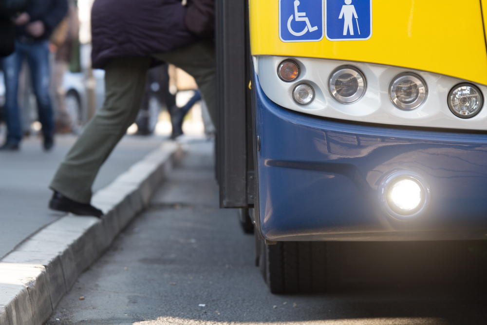 Public transport is a con to living in Florida. A gentleman is getting on a bus in this photo, but these buses are few and far between and their schedules's aren't convenient. 