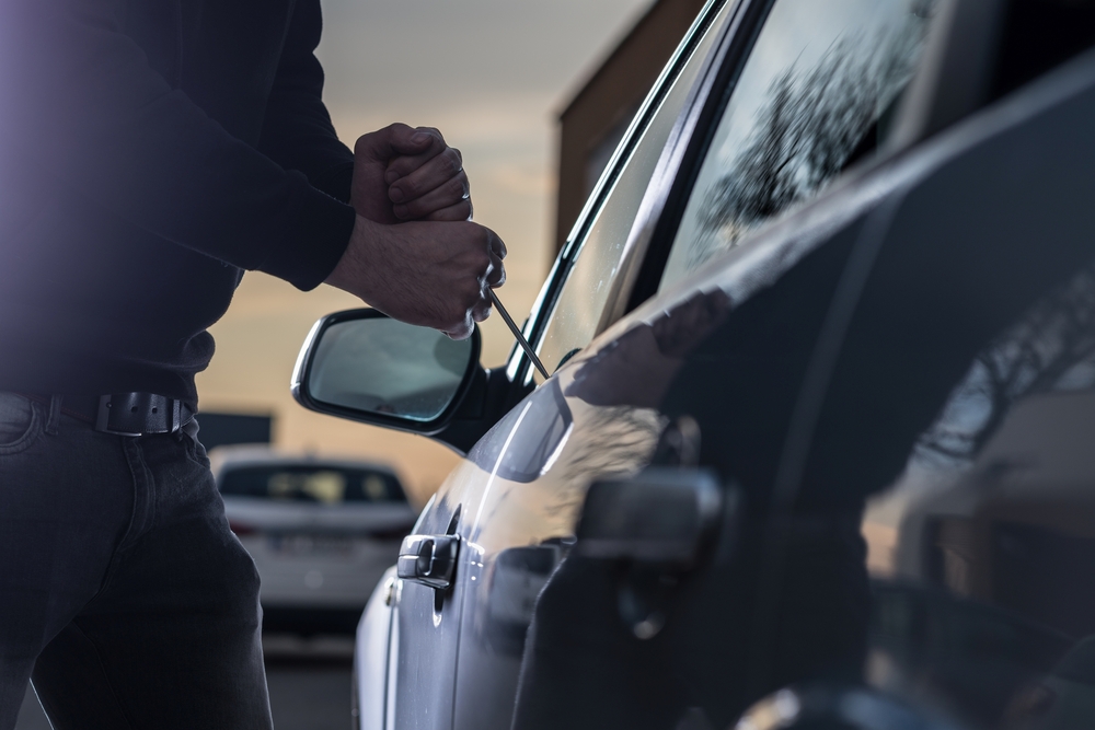 A man tries to break into a car with a tool: theft is common in Miami, sadly, which increases the city's crime rates. 