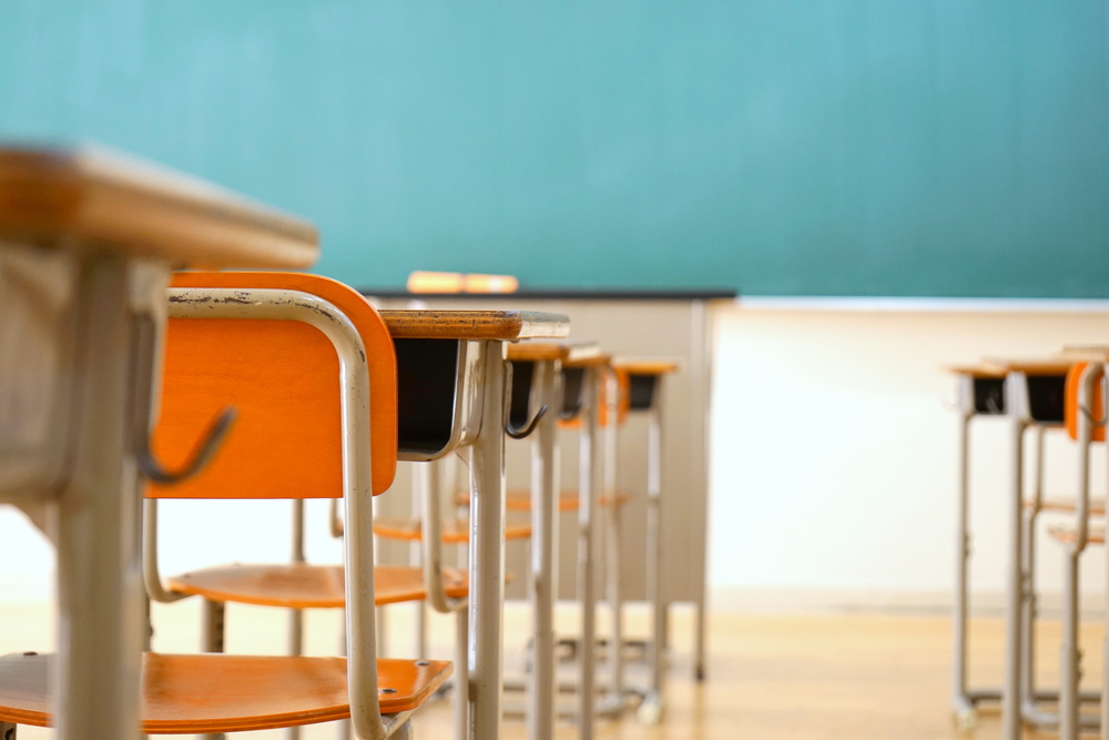 Lines of desks create rows that face a green chalk board at the public schools in Miami. 