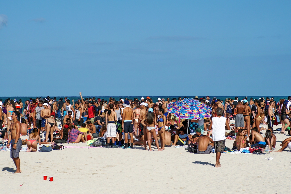 Living in Miami means dealing with spring break in Miami: these crowded beaches are shown in this photo, where springs breakers gather and clump together on the white sand, leaving no room. 