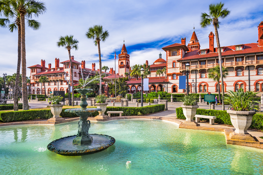 the downtown area of Saint Augustine  with a big fountain, Spain like buildings with orange roofs and beautiful palm trees all around it looks just like a town in Spain 