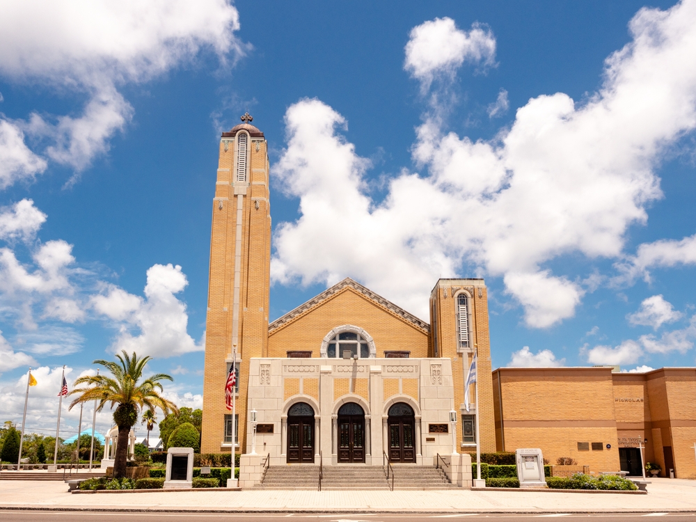 a Greek Orthodox church in Tarpon Springs Florida. the building is an orange color with big steps and a big tower. this is what makes Tarpon Springs one of the places in Florida that looks like Europe 