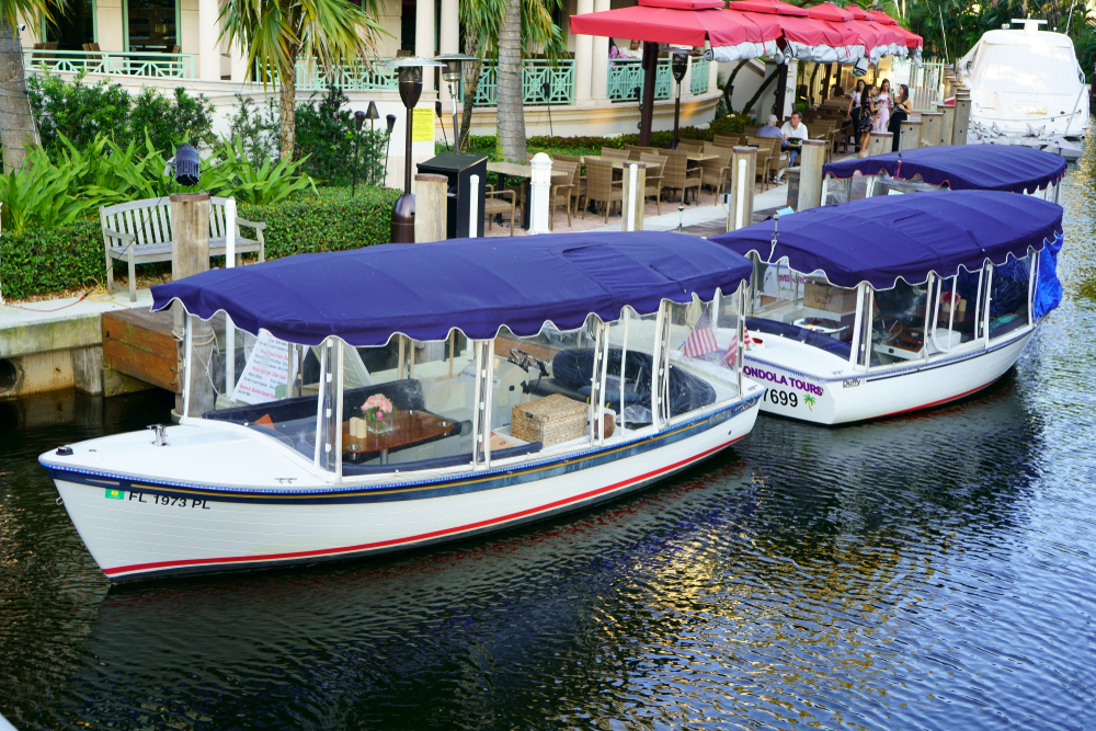 two gonalda boats in the canal in florida they are wider than the ones in Spain and have a purple cover on the top. you can ride these boats around in the water just like in Europe 