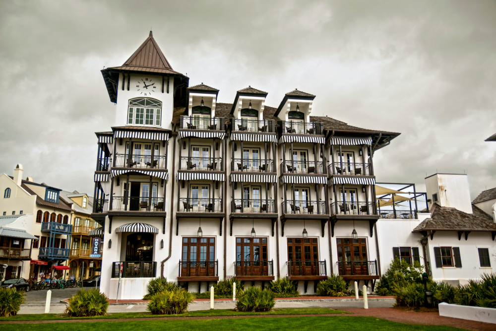  beautiful building in rosemary beach that looks like a Europen hotel. it has a tower and a brown European style roof  