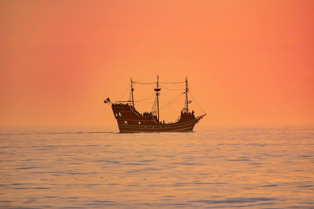 A pirate ship at sunset in Clearwater offers fun activities for families and stunning views while on the water. 