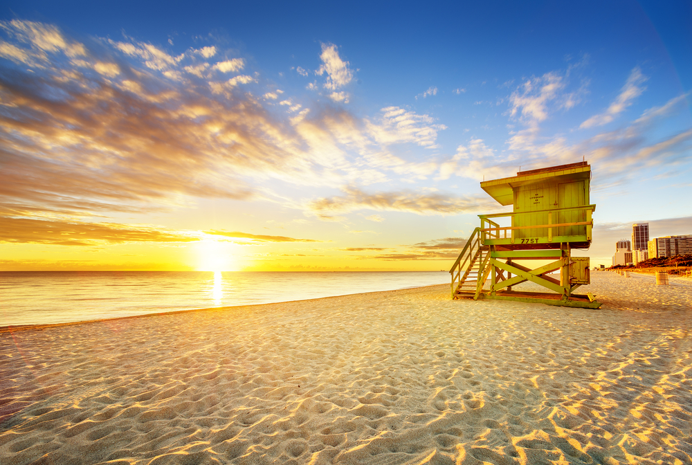A famous lifeguard and sand shack sits aglow in one of the most famous sunrises in Florida: the sunrises on South Beach! 