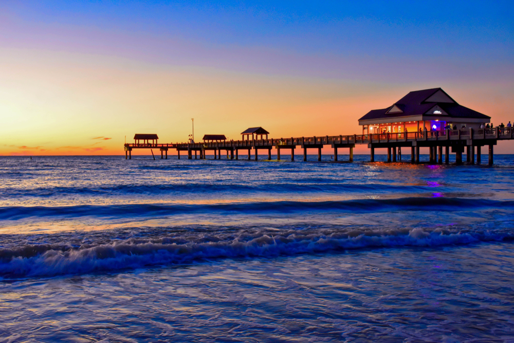 Clearwater's Pier 60 lights up at night and is one of the best places to see sunsets in Florida: the blue waters contrast the orange and yellow sun beyond the pier. 