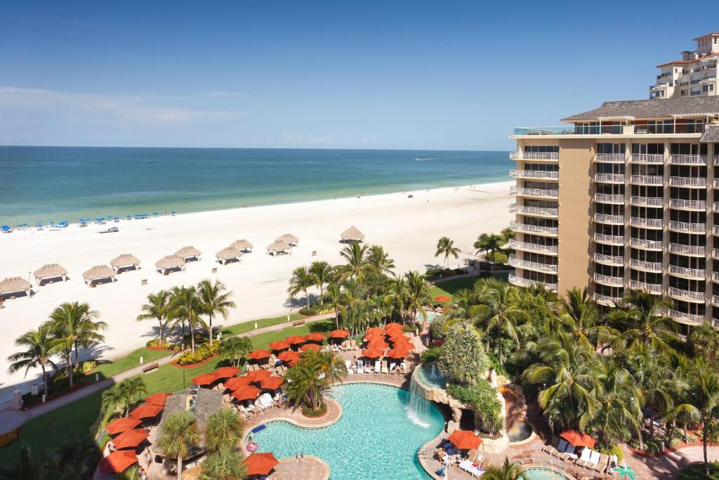 Picture of a beach with thatched umbrellas taken form a hotel room looking down on the pool. 