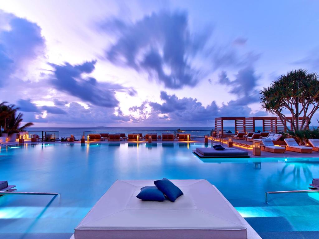 Beautiful hotel pool at sunset with the ocean and beach in the background. The article is about Florida hotels with a private beach. 