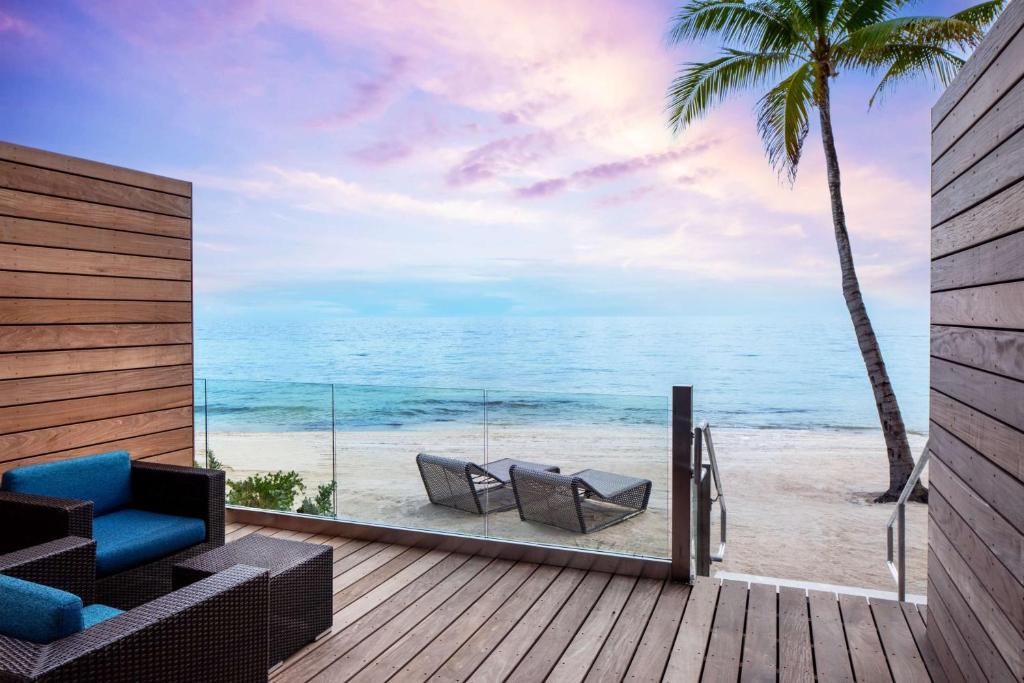 Two chairs on a beach in front of a terrace at sunset. 