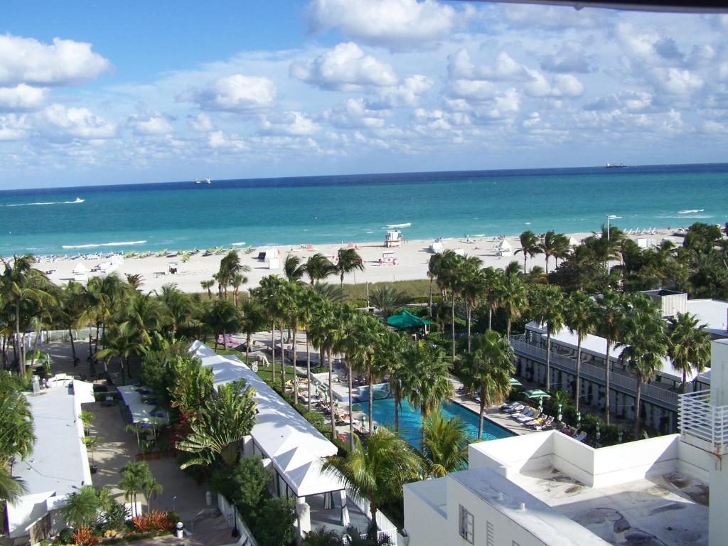 Picture of hotel complex with swimming pool and beach in the background. Palm tress surround the estate 