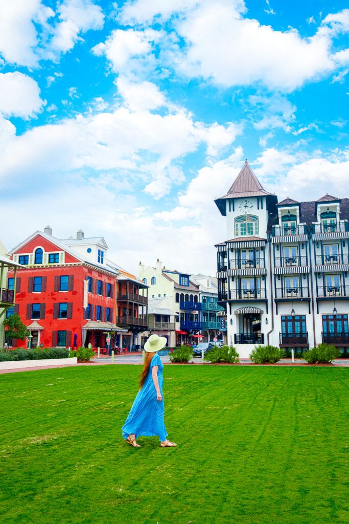 a girl in a blue Dress standing in front of the European influenced beach town of rosemary beach