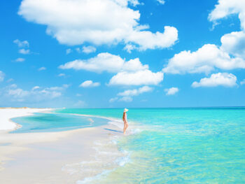 a girl standing in the water on the beach along 30A