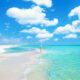 a girl standing in the water on the beach along 30A